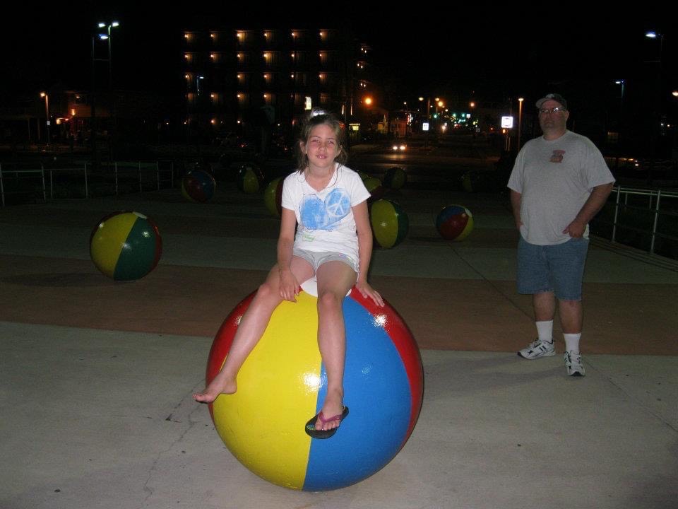 Young Jessi sitting on a beach ball at night at Wildwood, NJ