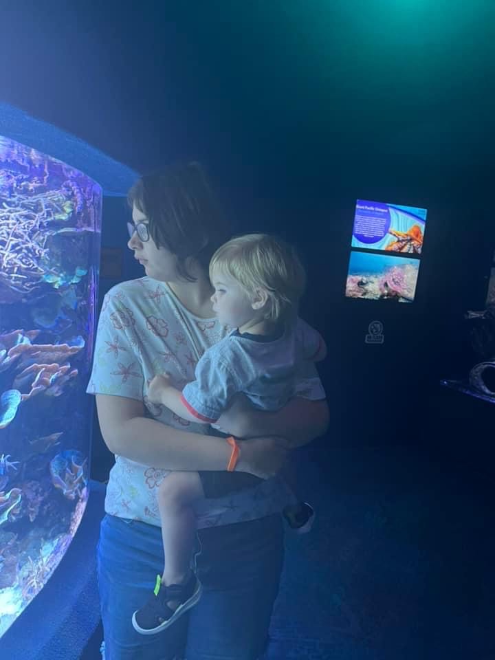 Jessi holding her nephew Henry as they look at fish at the Ripley's Aquarium