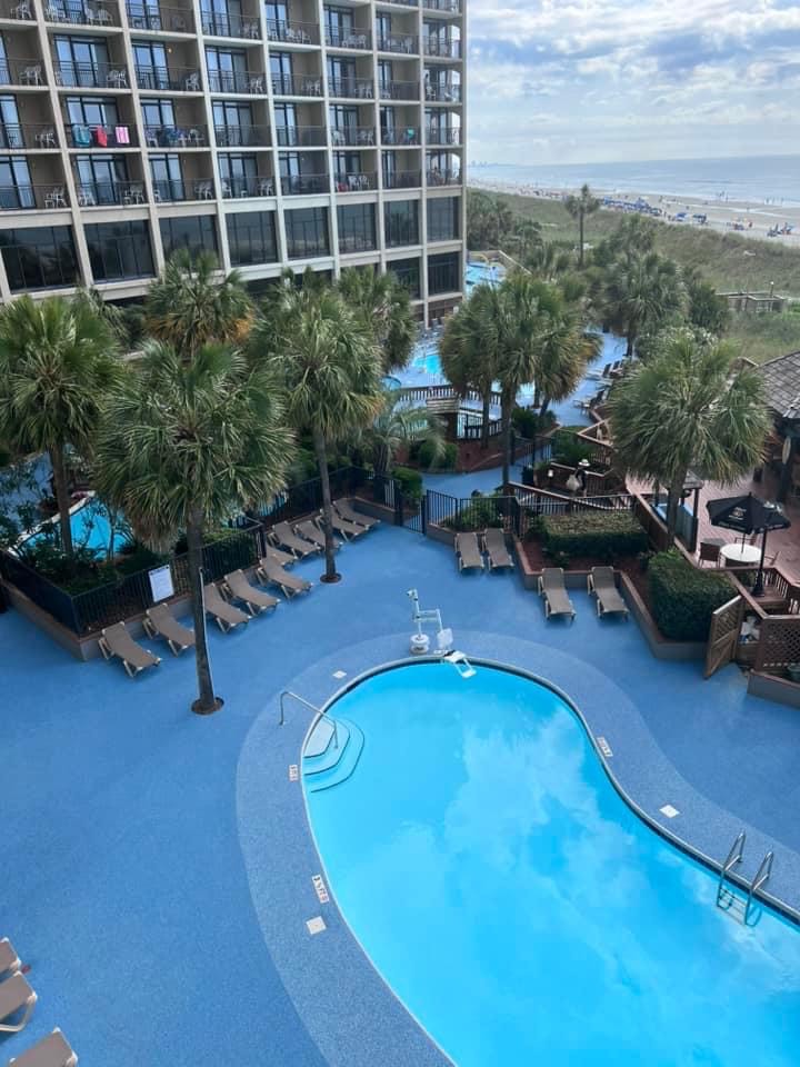 A view of the hotel room's pool with the beach in the distance